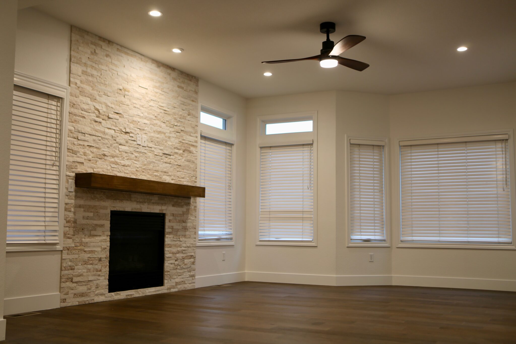 Living room with stone fireplace and large windows